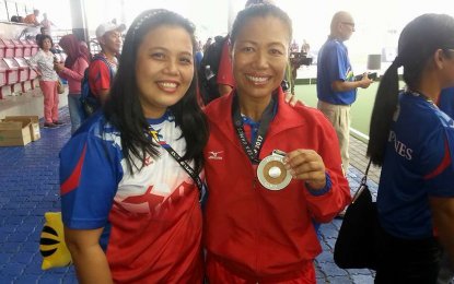 <p>Ronalyn Greenlees (right) shows the silver medal she won during the 2017 SEA Games in Kuala Lumpur, Malaysia. <em>(Photo taken from Greenlees' Facebook account)</em></p>